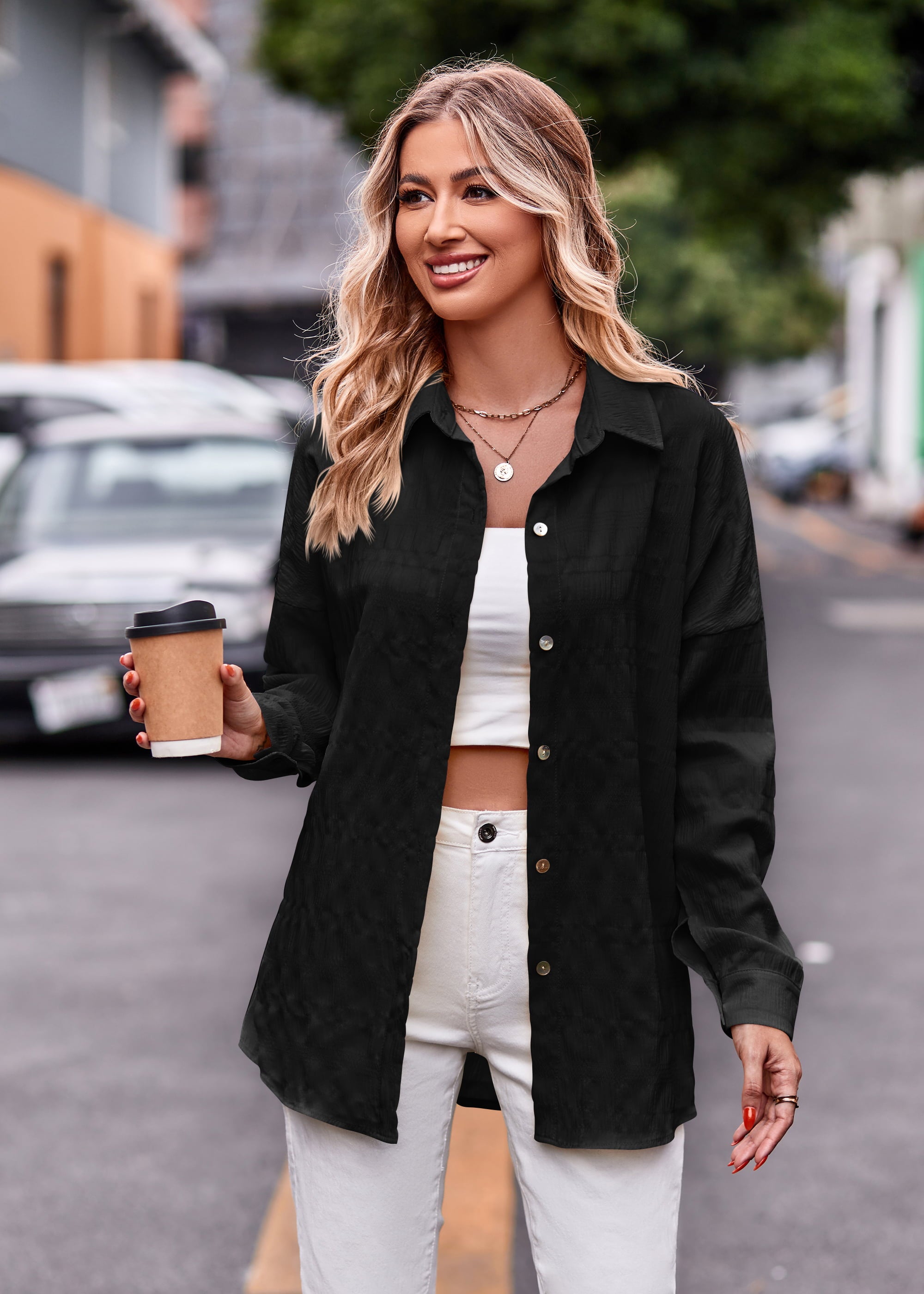 Black textured overshirt with relaxed fit and buttoned front, styled open over a white crop top.