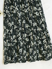 Botanical pleated midi skirt in black with a white floral print and crinkled texture.