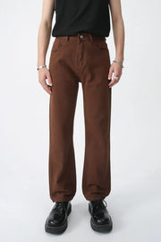 Relaxed fit chino trousers in chocolate brown, styled with black shoes.
