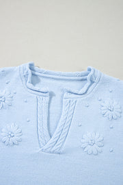 Sky blue knit sweater with embroidered floral details and notch neck.