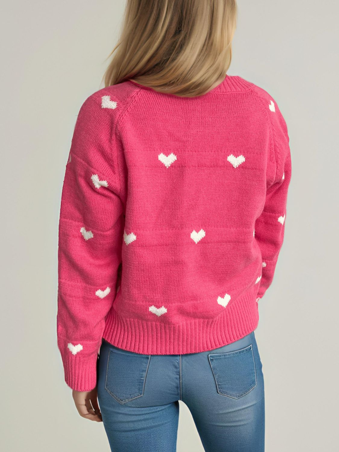 Hot Pink acrylic knit sweater with allover white heart pattern and ribbed cuffs and hem.