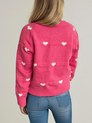 Hot Pink acrylic knit sweater with allover white heart pattern and ribbed cuffs and hem.