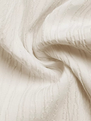 Cream cami dress fabric with textured vertical stripes and a subtle checkered pattern.
