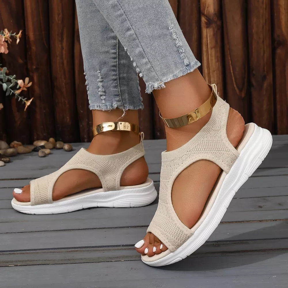 Beige knit open-toe platform sandals with white soles and gold ankle cuffs.