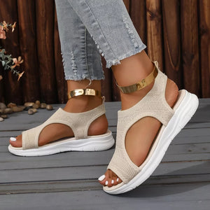 Beige knit open-toe platform sandals with white soles and gold ankle cuffs.