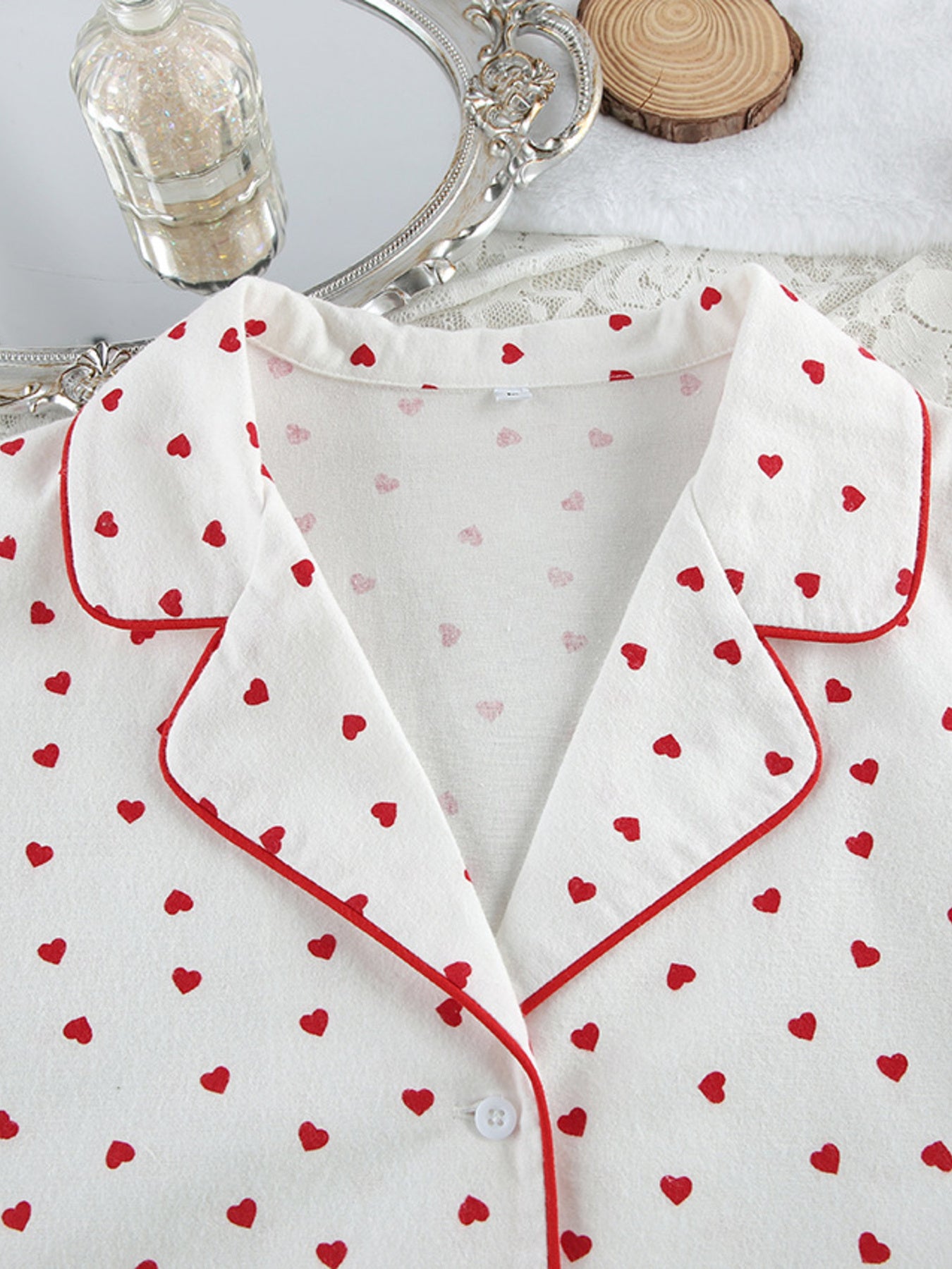 White cotton pajama top with red heart pattern and contrast piping.