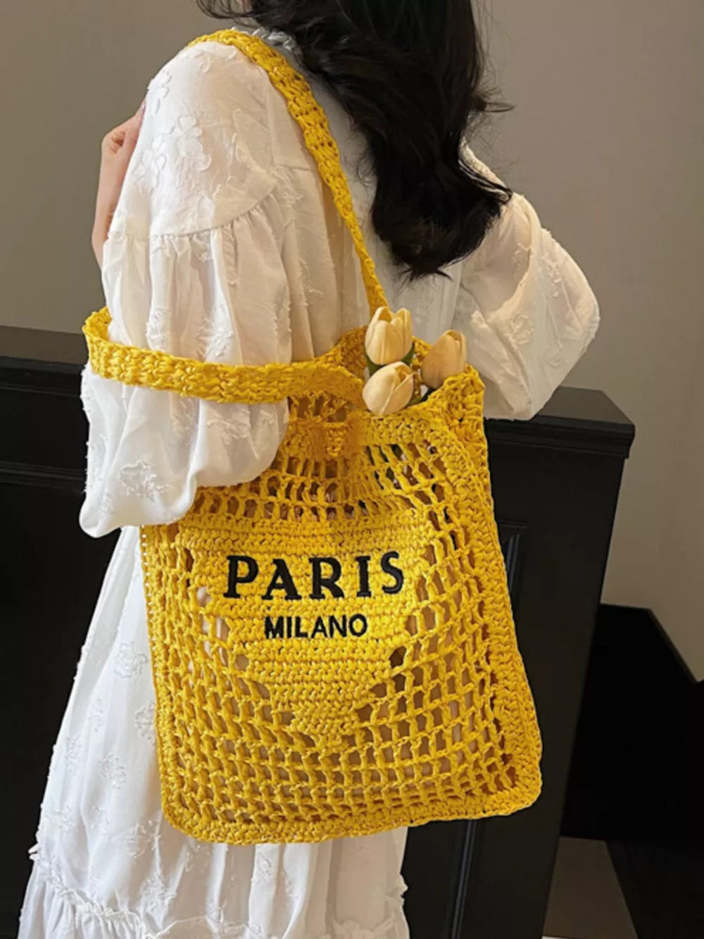 Yellow crochet tote bag with "PARIS MILANO" text detail and flowers.