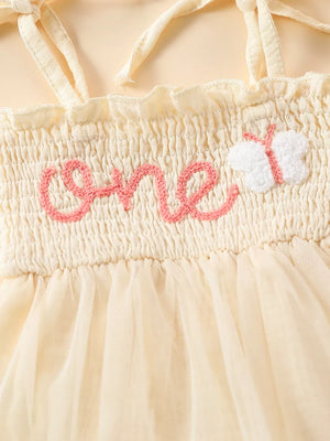 Cream smocked baby bodysuit with pink embroidered "one" and butterfly detail, tulle skirt.