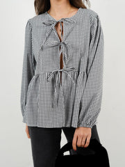 Black and white gingham tie-front peplum blouse with voluminous sleeves and a keyhole neckline.
