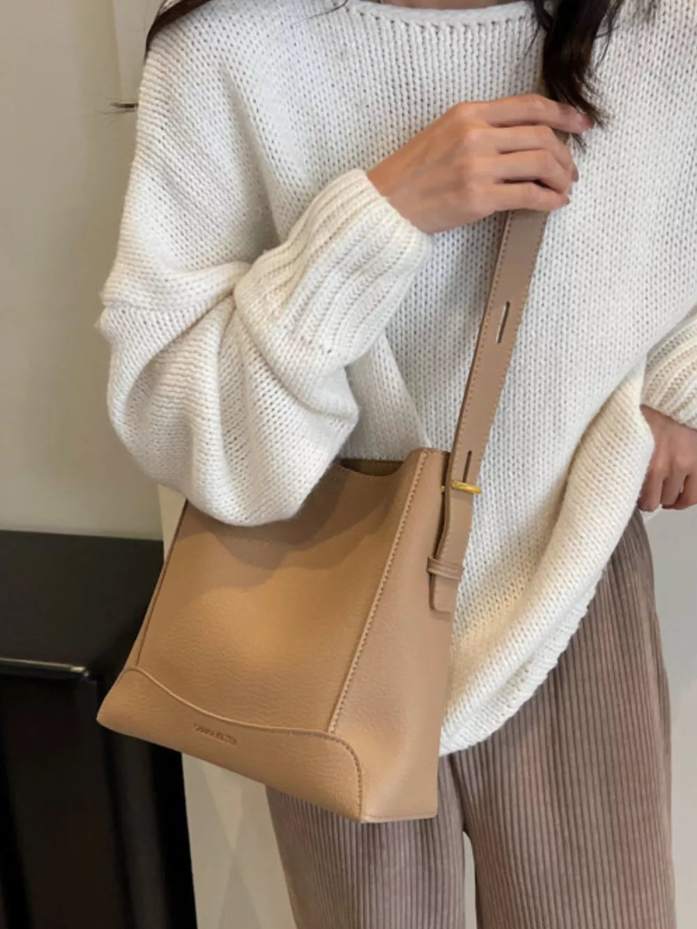 Textured pebbled leather crossbody bag in khaki with adjustable strap.