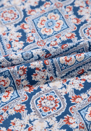 Bohemian print blouse in dusty blue with bell sleeves and a floral tile pattern.