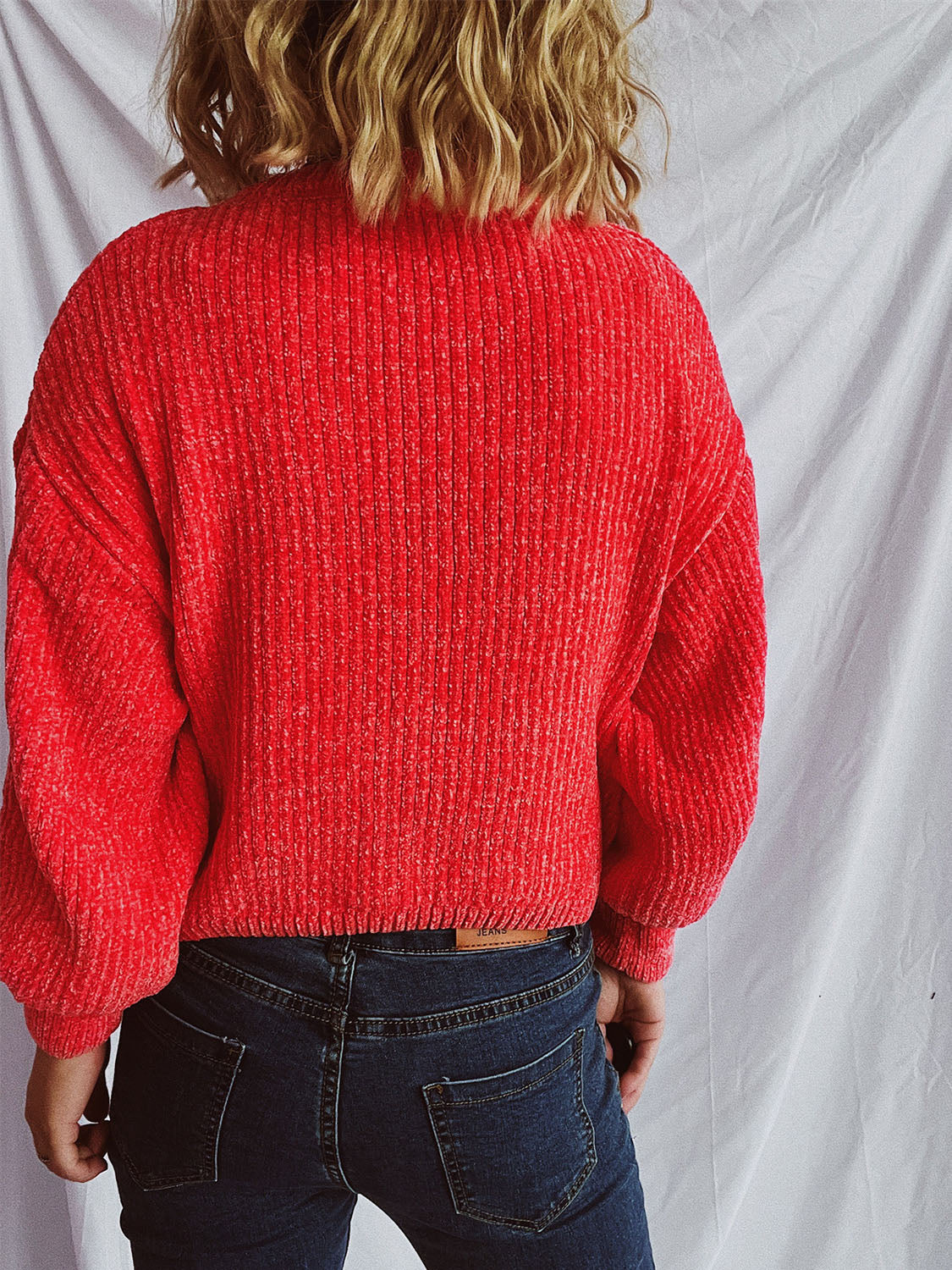 Textured ribbed knit crewneck pullover in strawberry red, with relaxed fit and balloon sleeves.