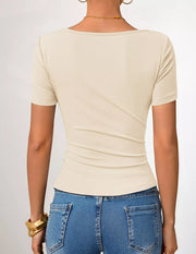 Beige asymmetrical maternity t-shirt with short sleeves and a fitted silhouette.