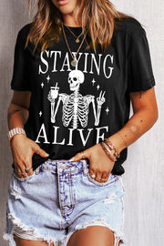 Black graphic tee with skeleton and "Staying Alive" text, short sleeves, crew neck