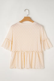 Beige textured blouse with ruffle hemline and flutter sleeves.