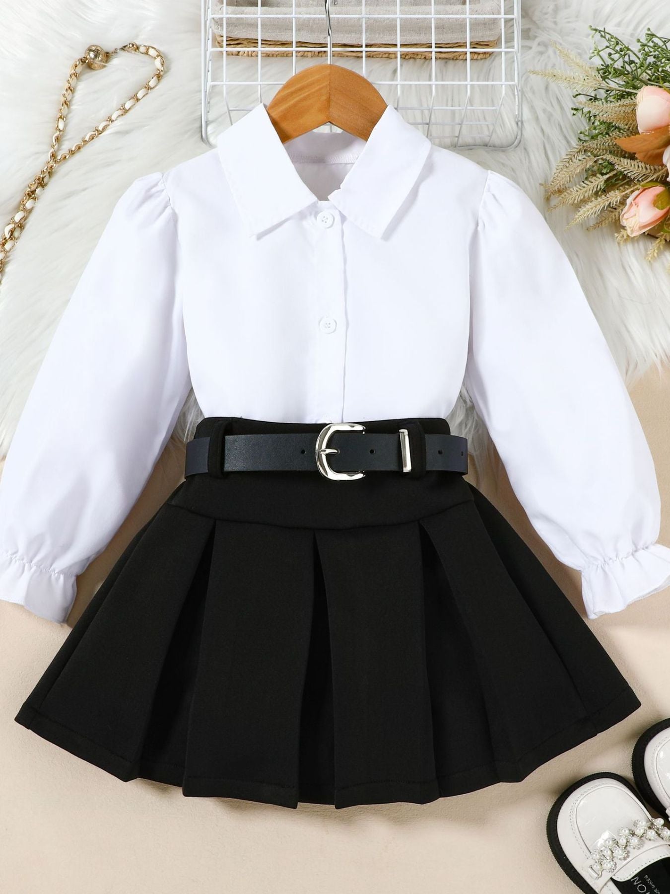 Toddler white collared long sleeve shirt with black pleated skirt and belt