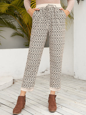 Geometric print drawstring trousers with cuffed hems and a cream waistband.