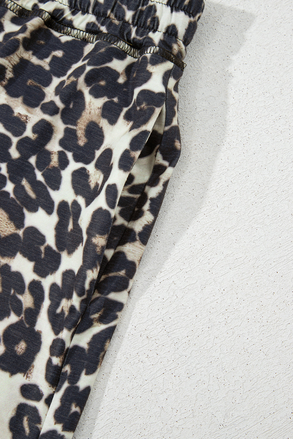 Relaxed leopard print lounge pants with elastic waistband and side pocket detail.