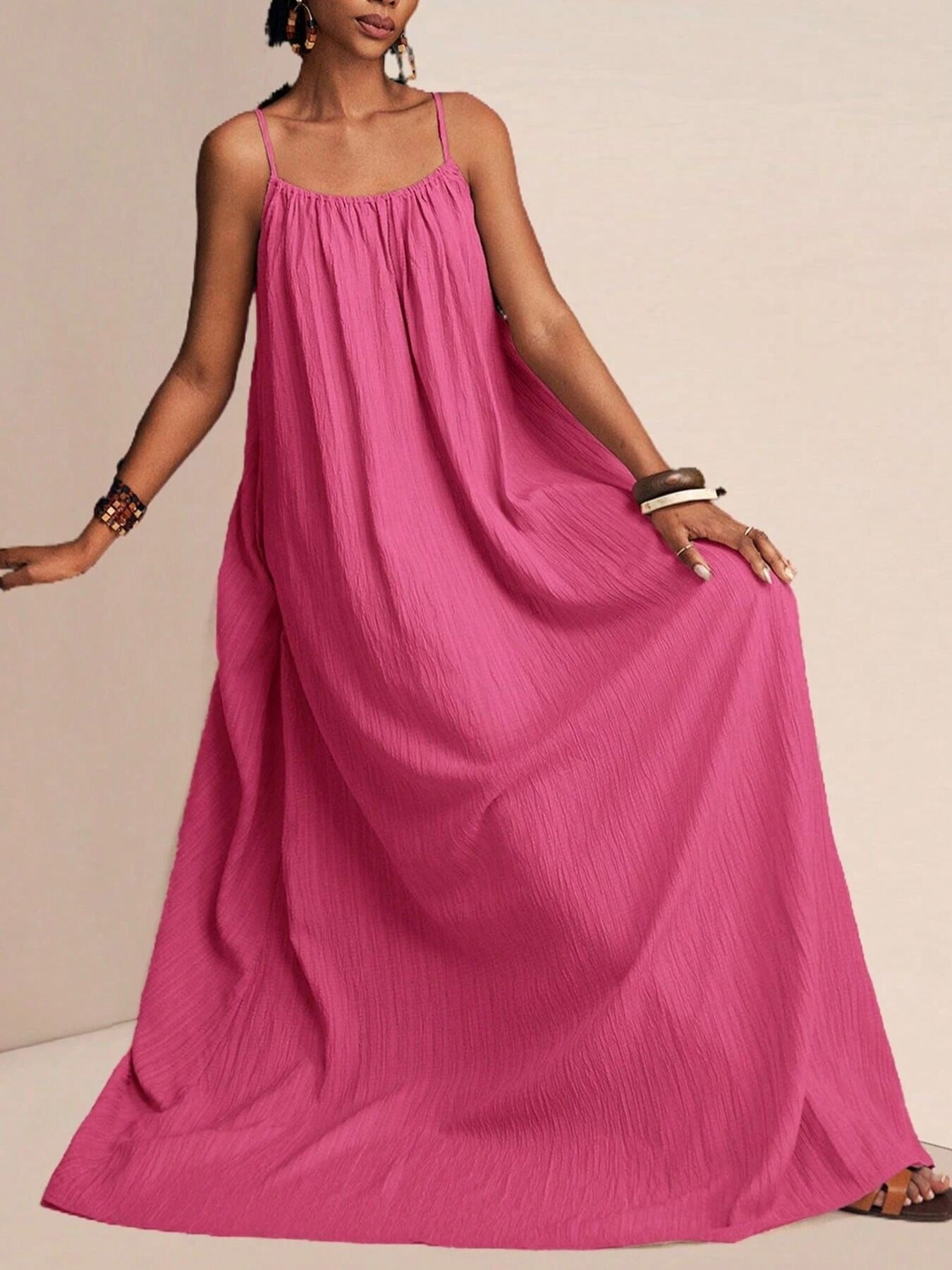 Fuchsia pink crinkle maxi dress with spaghetti straps and a flowy silhouette.