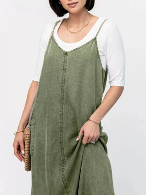 Moss denim maxi dress with V-neck and adjustable straps, styled with a white tee.