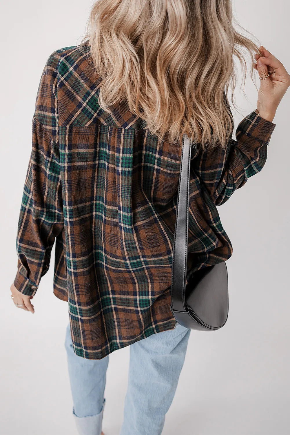 Plaid jacket in brown, green, and navy with button cuffs, styled with light wash jeans and a black crossbody bag.