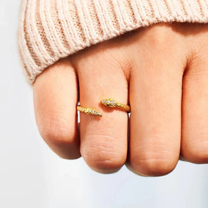 Gold bypass ring with diamond accents, shaped like a braided serpent.