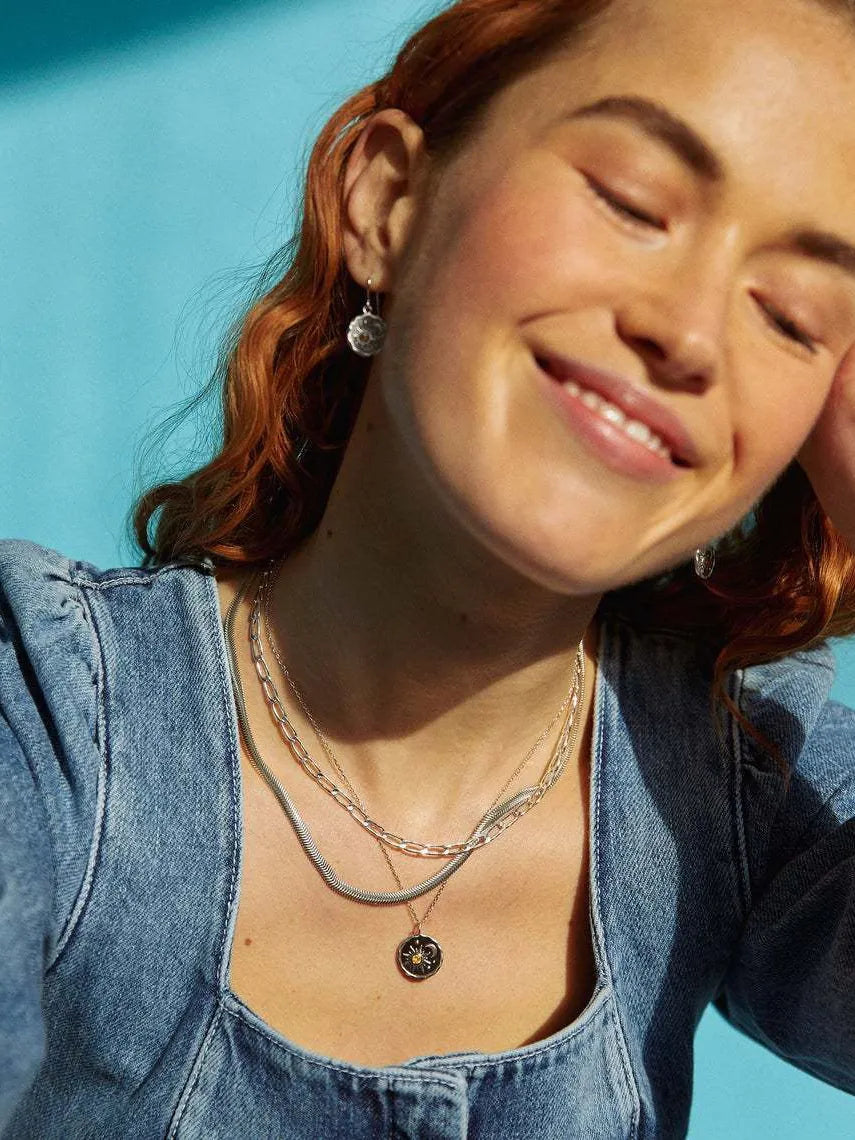 Gold celestial medallion zircon pendant necklace with layered chains and matching earrings.