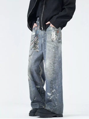 Men's wide-leg jeans in dusty blue denim with paint splatters and chain detail.