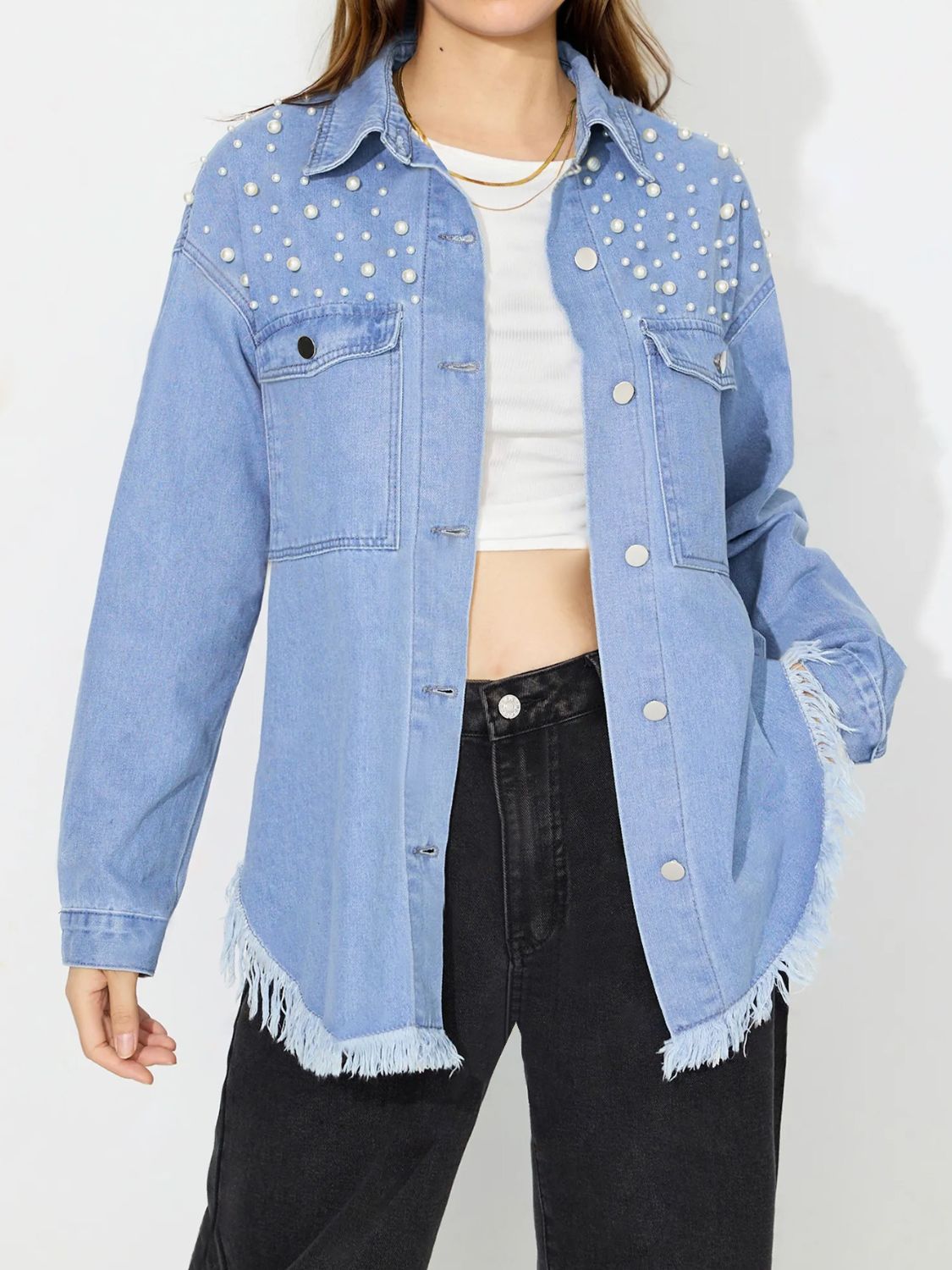 Light wash denim shirt with pearl embellishments and frayed hem.