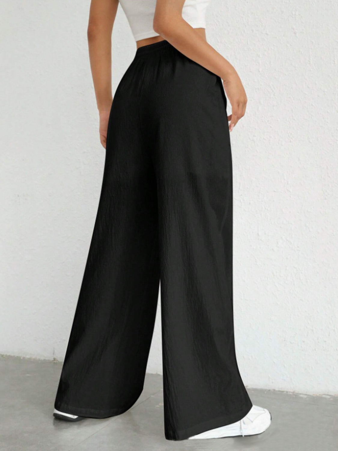 Black linen wide-leg drawstring trousers with a relaxed fit.