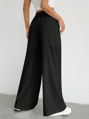 Black linen wide-leg drawstring trousers with a relaxed fit.
