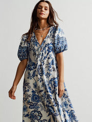 Maxi dress with blue floral print, tie-neck, puff sleeves, and V-neck.