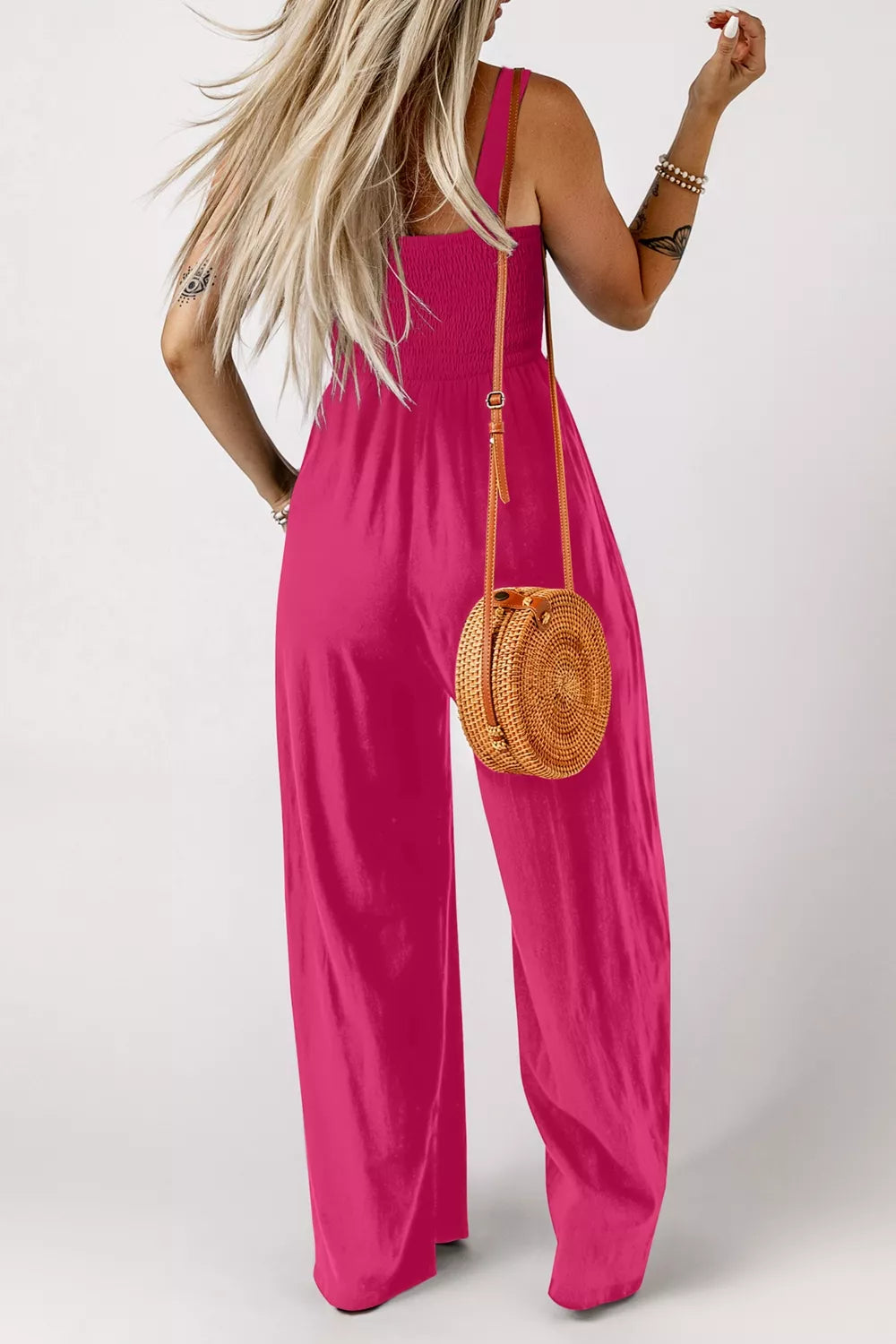 Smocked bodice wide leg romper in deep rose, with adjustable straps and a relaxed fit.