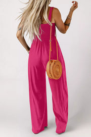 Smocked bodice wide leg romper in deep rose, with adjustable straps and a relaxed fit.