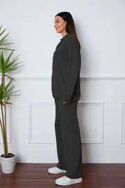 Black knit polo co-ord set with relaxed fit and wide leg pants.