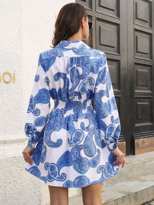 Cobalt blue paisley print shirred waist mini dress with long sleeves and collar.