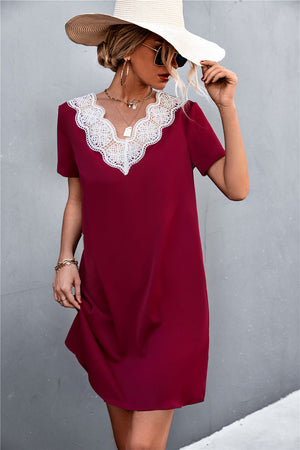 Wine v-neck shift dress with white lace trim and short sleeves.
