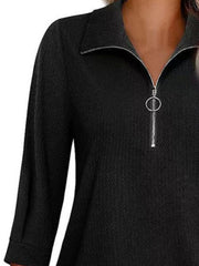 Black textured zip-front polo top with a ring pull zipper and collared neckline.