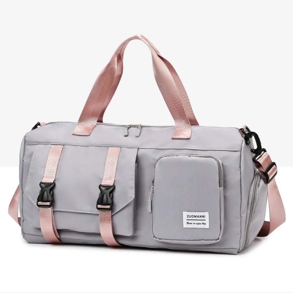 Gray duffel bag with pink buckle straps and handles, multiple pockets
