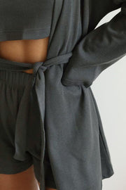 Dark Gray waffle knit lounge robe tied at waist over matching shorts and crop top.