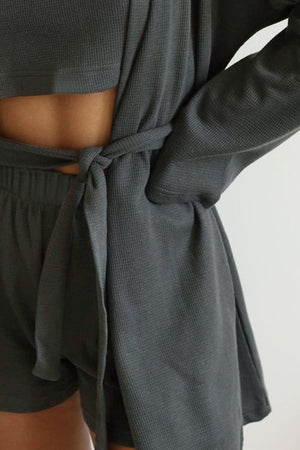 Dark Gray waffle knit lounge robe tied at waist over matching shorts and crop top.