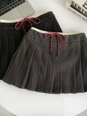 Chic drawstring pleated skirt in dark gray and black with white trim and red-striped ties.
