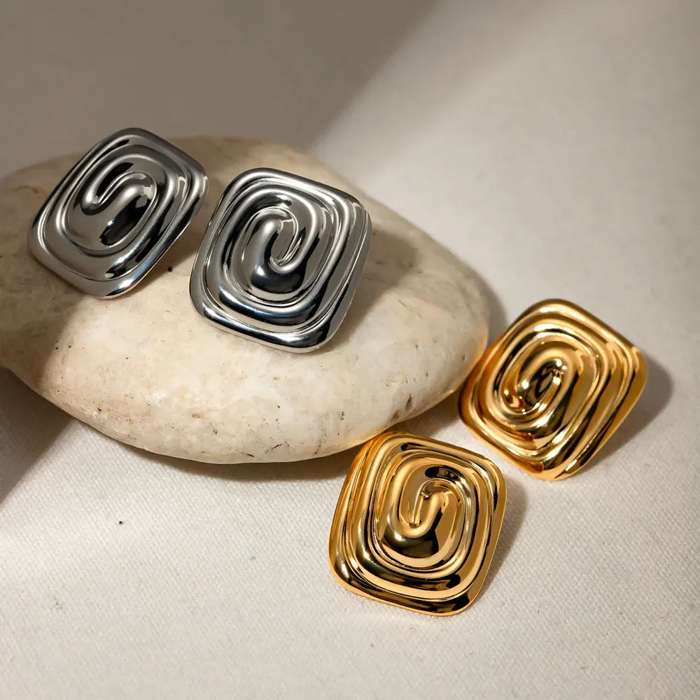 Sculpted swirl square earrings in gold and silver with a contemporary, chic design.