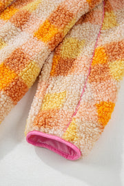 Checkerboard sherpa jacket in tangerine with pink contrast trim and collar detail.