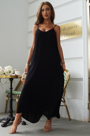 Black linen maxi dress with spaghetti straps and pockets, styled casually.