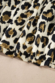 Leopard print tie-neck peplum blouse with ruffled hem detail.