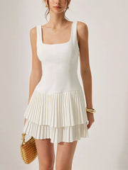 White square neck mini dress with tiered pleated skirt and sleeveless design.