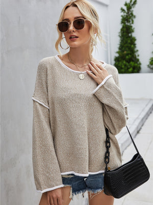 Beige knit pullover sweater with white trim and boat neckline.