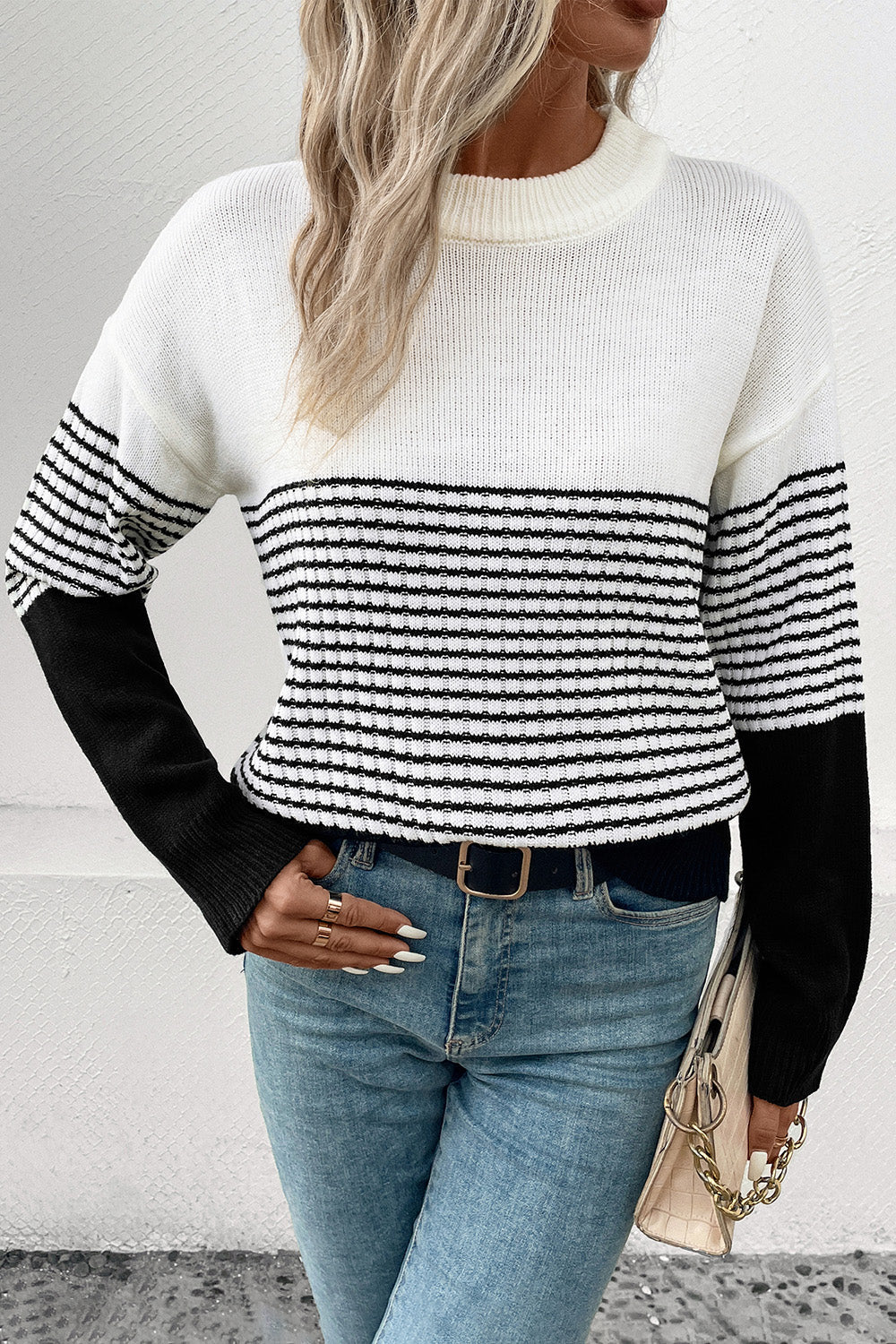 Colorblock stripe crewneck sweater in white with black sleeves and horizontal stripes.