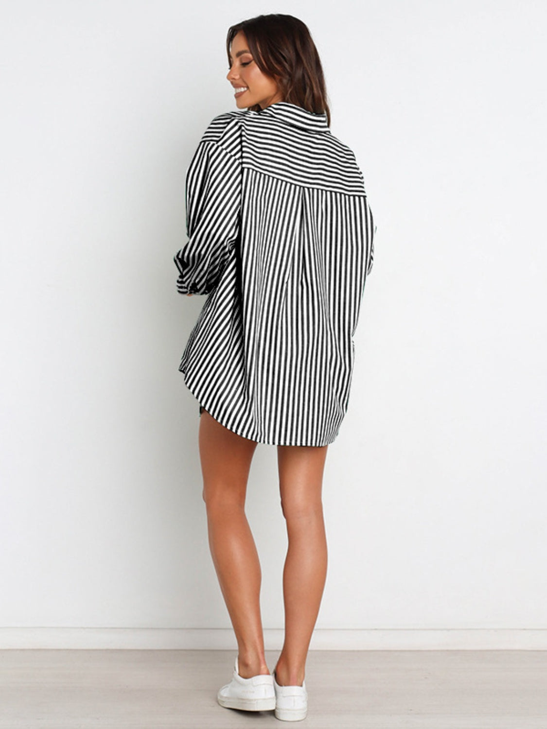 Oversized black and white striped shirtdress with a button-down collar and long sleeves.